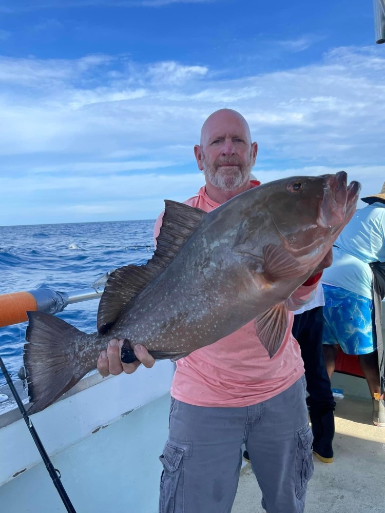 a man holding a fish in the water