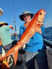 a man holding a fish on a boat
